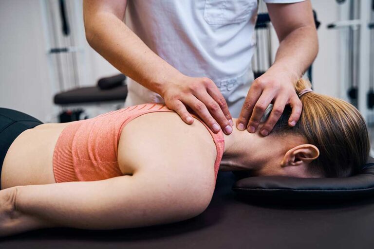 Person resting at home with a warm compress on a mildly sore lower back after treatment.